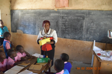 A female teacher in Kenya, is teaching Numeracy concepts by using teaching materials. 