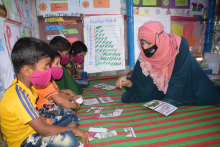  A female ECE teacher is  teaching students to read by using learning through play methodology. 